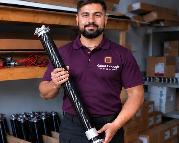 Good Enough Garage Doors technician holding a single torsion spring