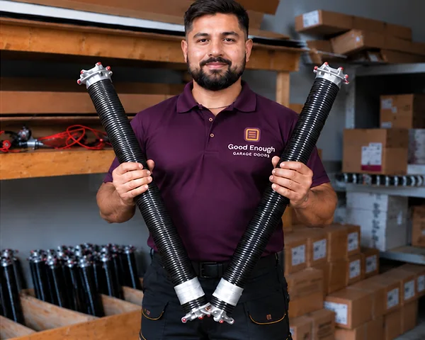 Good Enough Garage Doors technician holding a matched pair of torsion springs